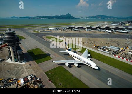 A Singapore Airline Airbus A380 taxis away from the terminal at Hong Kong International Airport (HKIA), Chek Lap Kok, seen from the control tower Stock Photo