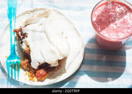 Rhubarb shortcrust cake with meringue on top with strawberry smoothie Stock Photo