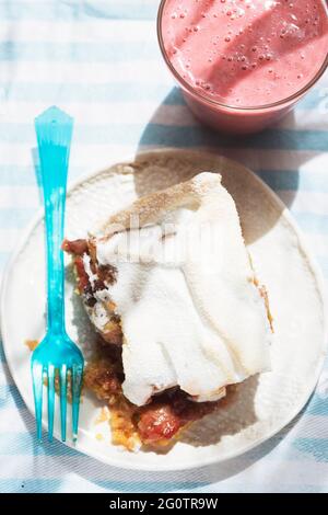 Rhubarb shortcrust cake with meringue on top with strawberry smoothie Stock Photo