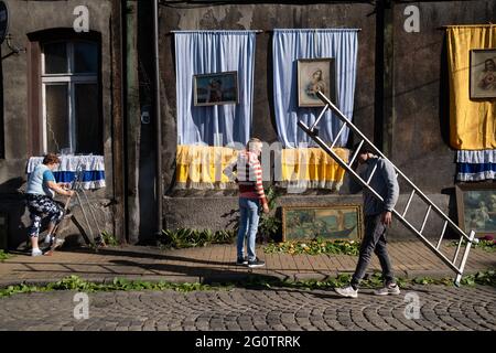 Swietochlowice, Lipiny, Poland. 03rd June, 2021. A man with a ladder and two women seen decorating the street during the procession. Corpus Christi (Boze Cialo) it is a traditional feast celebrated in the Catholic Church. From the early morning hours, residents of the Lipiny- district in Swietochlowice, Silesia, decorate their streets and build altars. They are waiting for the procession of the faithful in traditional costumes which goes around the streets. The priest with the monstrance goes with them too. Credit: SOPA Images Limited/Alamy Live News Stock Photo