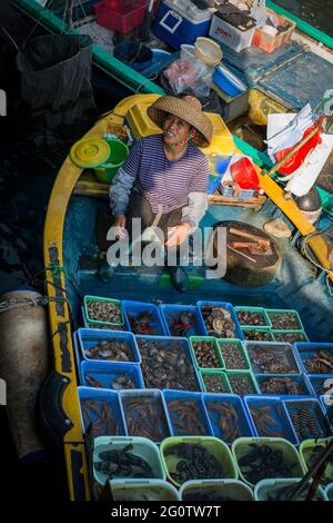 A local fisherwoman sells her catch directly from her boat at the waterfront, Sai Kung, New Territories, Hong Kong Stock Photo