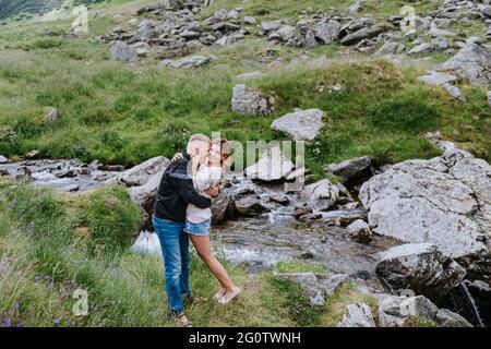 Romantic summer love story on a sunset in mountains. Young girl and boy in love. Stock Photo