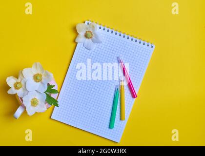 Pencils notepad in a cage mug with flowers flowers Stock Photo