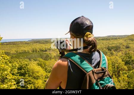 TOBERMORY, CANADA - May 30, 2021: A women takes a photo of a lookout in Georgian bay - editorial tourism themed photo. Stock Photo