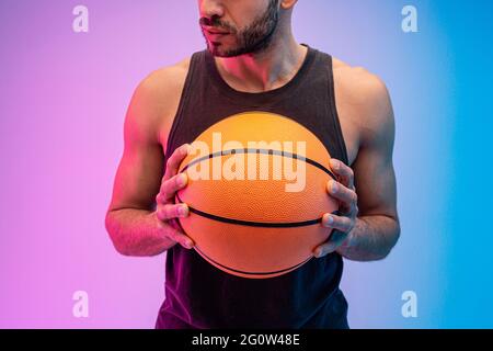 Serious man hold basketball ball in hands Stock Photo