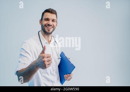 Smiling male doctor showing thumb up gesture Stock Photo