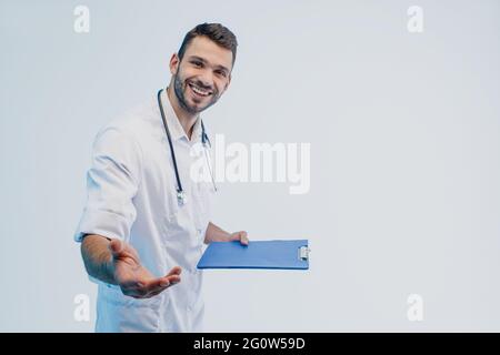 Smiling young european male doctor hold clipboard Stock Photo