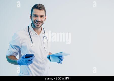 Male doctor with mobile phone and digital tablet Stock Photo