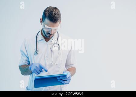 European male doctor use digital tablet in studio Stock Photo