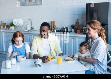 happy interracial family having breakfast in kitchen Stock Photo