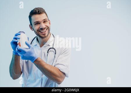 European male doctor holding bottle of pills Stock Photo