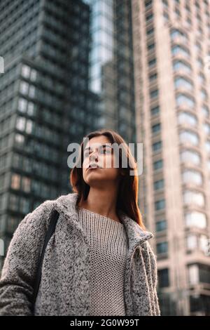 Thoughtful non-binary woman standing on street in city Stock Photo