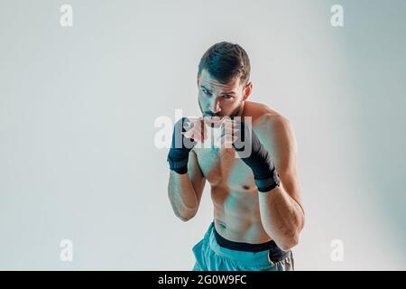 Young bearded european boxer is boxing in studio Stock Photo
