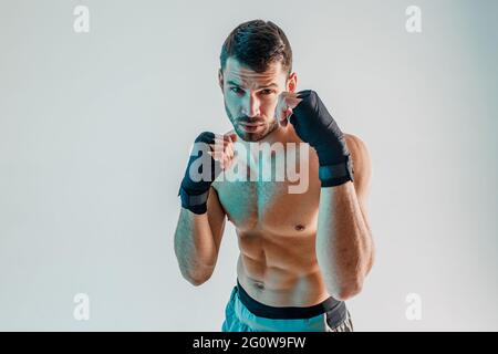Young bearded european boxer is boxing in studio Stock Photo