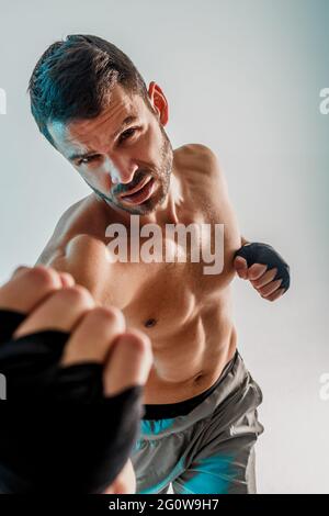 Serious young bearded european boxer is boxing Stock Photo