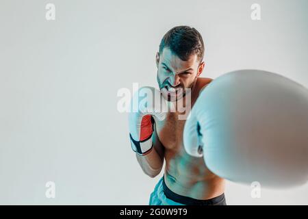 Angry young bearded european boxer is boxing Stock Photo
