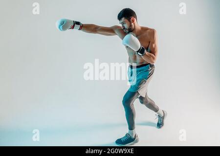 Concentrated european boxer is boxing in studio Stock Photo