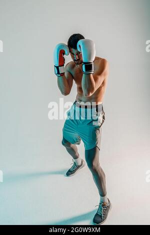 Concentrated european boxer is boxing in studio Stock Photo