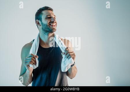 Smiling young sportsman with towel in studio Stock Photo