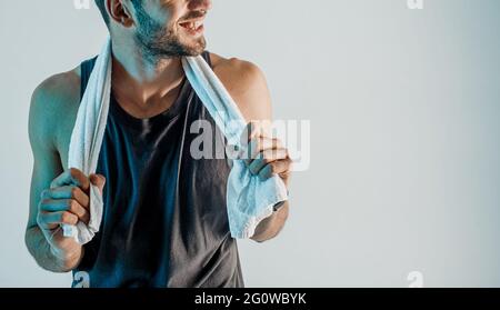 Smiling young sportsman with towel in studio Stock Photo
