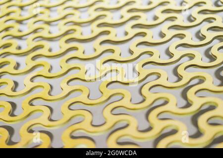 Abstract background, a repeating pattern of gold curved round cells in a gold lattice. Stock Photo
