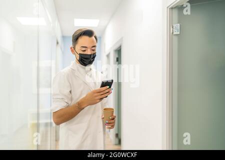 doctor consulting their smartphone on their break Stock Photo