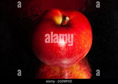 red delicious apple on black reflective background Stock Photo