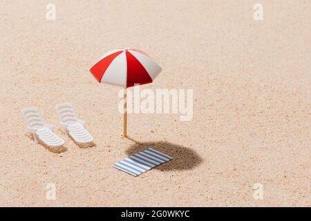 White and red beach umbrella, sun chairs and blue and white striped towel. Beach set for sunny days. Summer holiday concept. Copy space. Stock Photo