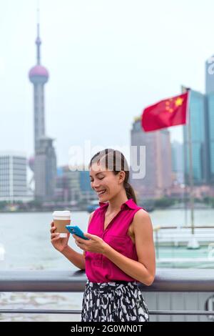 Business woman in Shanghai China using smart phone in Pudong financial district Stock Photo