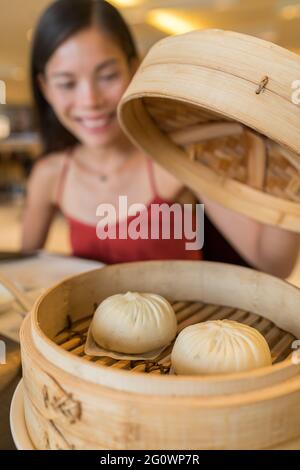 Asian woman eating at chinese dim sum restaurant Stock Photo