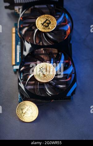 Bitcoin coin on a powerful graphics card for mining and earning cryptocurrency concept on a dark background. Technologies of the future currency. Top Stock Photo