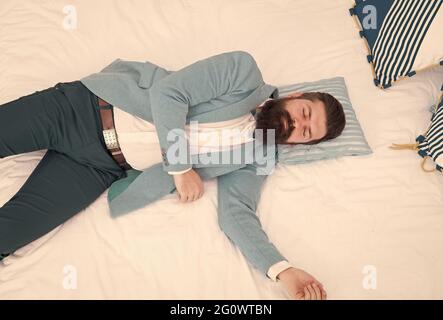 Recovery and recharging. Feel tired and sleepy. Sleepy guy in formal clothes sleep bed top view. Lack of sleep. Need more sleep. Evening time Stock Photo