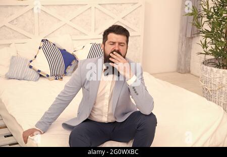 Tired of waiting. Elegant man yawn sitting on bed. Bearded man in classy style. Fashion look of groom. Wedding man. Formal wear for gentleman. Fashion Stock Photo