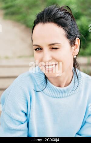 Close-up portrait of nice cute attractive lovely playful smiling young woman with one eye wink Stock Photo