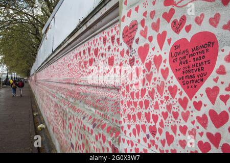 London, UK. 1 May, 2021. The National Covid Memorial Wall on the South Bank of the River Thames.  The National Covid Memorial Wall is a public mural comprising thousands of red and pink hearts painted by volunteers in order to commemorate the victims of the COVID-19 pandemic in the United Kingdom. Credit: Mark Kerrison/Alamy Live News Stock Photo