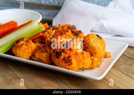 Vegetarian cauliflower buffalo wings served with blue cheese dipping sauce and sliced carrots and celery Stock Photo