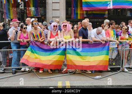 Members of the public watch as the Jubilee Pride Parade passes by where it was estimated 1million people attended the celebrations in central London. Stock Photo