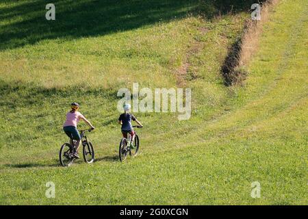 Two girls on mtb bikes. Mother and daughter riding on a trail. Stock Photo