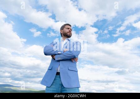 handsome man businessman in formal suit check time on wristwatch on sky background, agile business. Stock Photo