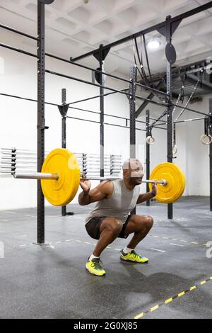 Black male sportsman doing intense weight training in the gym. Space for text. Stock Photo