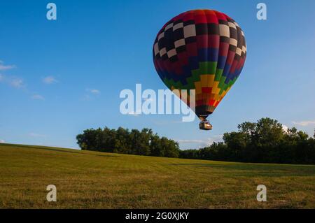 A hot air balloon floats above a a field near Indianola, Iowa, as the pilot prepares to land. Stock Photo