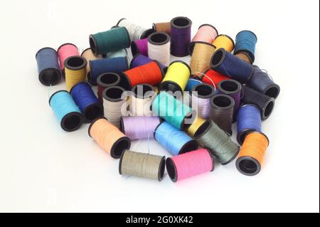 Spools and bobbins of thread for sewing in different colors, isolated on white background Stock Photo