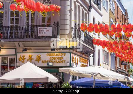 Gerrard Street on London's Chinatown with red Chinese lanterns hanging over a restaurant on a sunny day. London Stock Photo