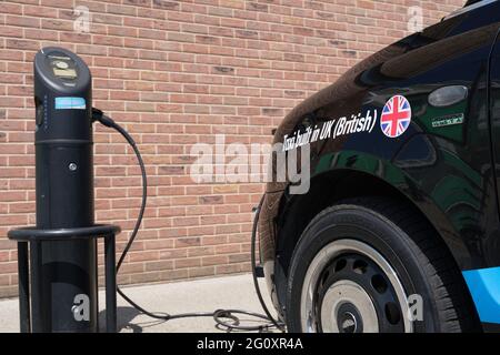 Taxi built in UK (Britain) plug into electical ccharging point in car park, Kent, England Stock Photo