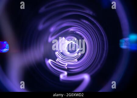 Plasma tunnel and violet electric flashes as abstract futuristic neon background. Stock Photo