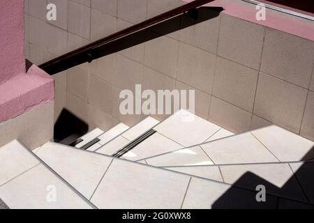 stairs downhill lined with ceramic tiles with a railing on the wall, exterior architecture close-up, nobody. Stock Photo