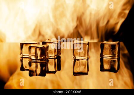 five ice cubes on a black background, in the background flames Stock Photo