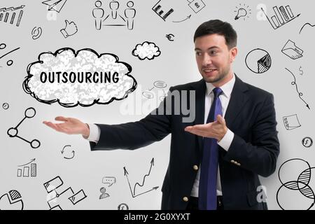 Business, technology, internet and network concept. Young businessman thinks over the steps for successful growth: Outsourcing Stock Photo
