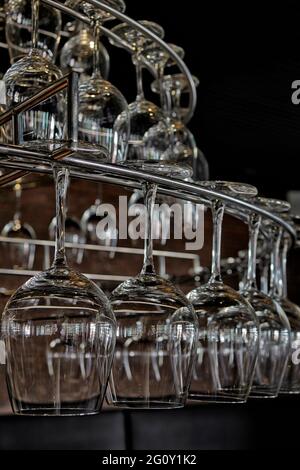 Wine glasses hanging from a rack Stock Photo