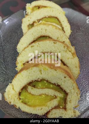 A Swiss roll, jelly roll, roll cake, cream roll, roulade or Swiss log is a type of rolled sponge cake filled with whipped cream, jam, or icing Stock Photo